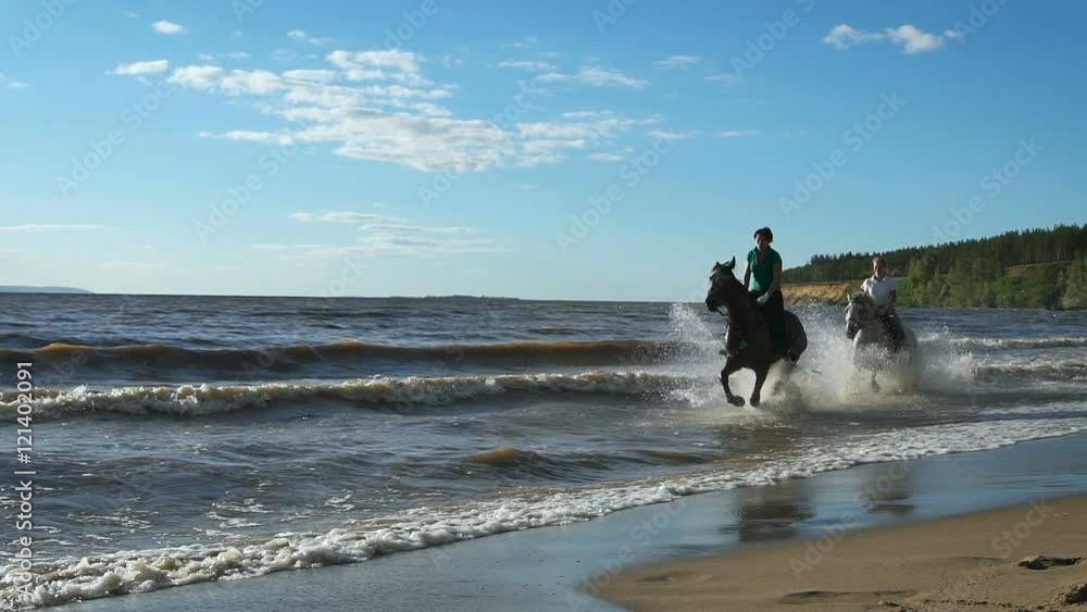 Beautiful young women horse riding at a beach. Enjoying beautiful landscape Galloping at a beach Beautiful young women horse riding at a beach. Enjoying beautiful landscape Galloping at a beach