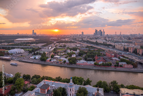 Panoramic view of sunset above Moscow city and cloud reflections in river with traveling boats