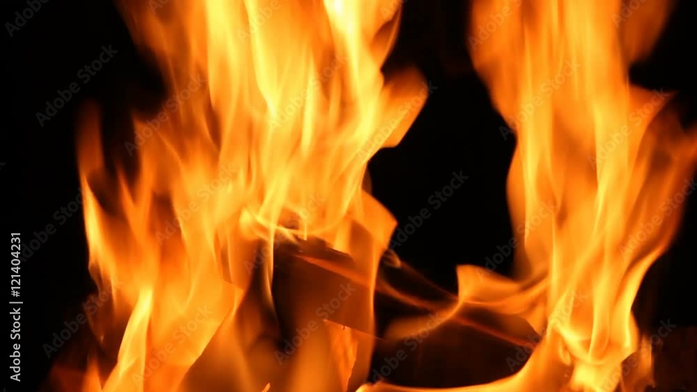 Closeup of a large fire. Wooden planks to the fire. The fire is lit in the night. Closeup of a large fire. Wooden planks to the fire. The fire is lit in the night.