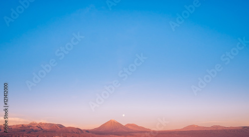 The moon rising over the red mountains of San Pedro De Atacama desert, Chile