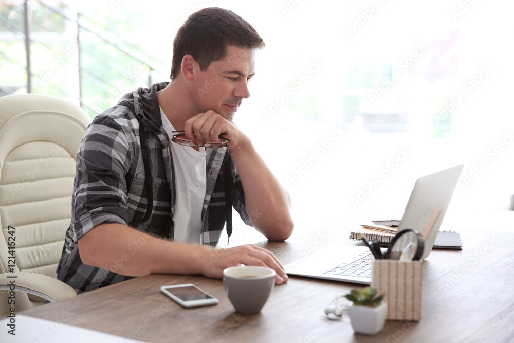 Handsome man working on laptop Handsome man working on laptop