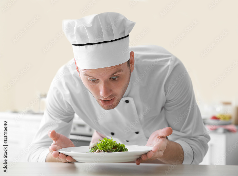 Young chef cook putting dish on table Young chef cook putting dish on table
