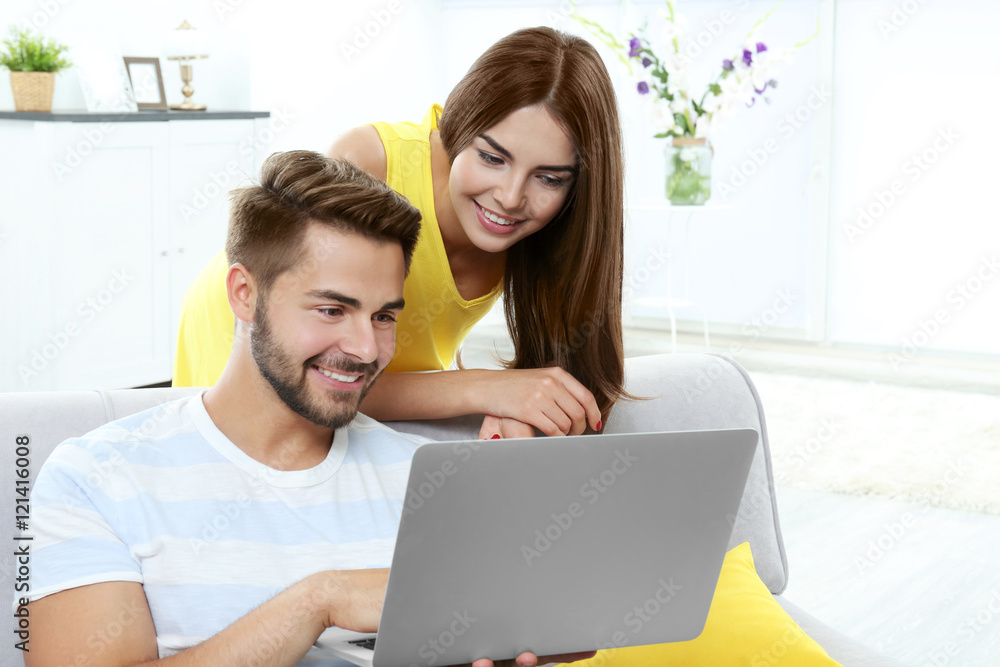 Beautiful young couple using laptop at home Beautiful young couple using laptop at home