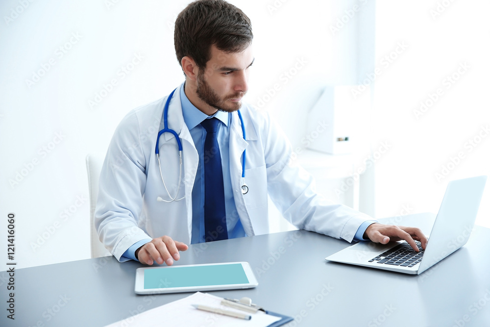 Male doctor at work in clinic office Male doctor at work in clinic office