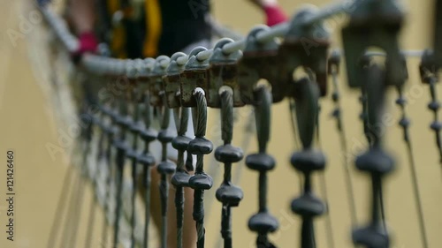 man walking on the swing bridge in the rope park 
