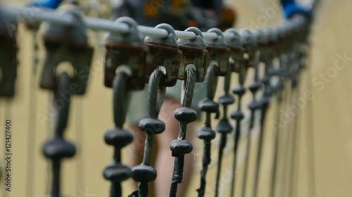 man walking on the swing bridge in the rope park 
