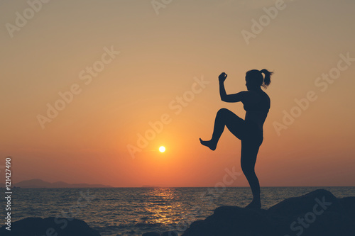 Silhouette woman. she exercise muay chaiya or thai boxing on the