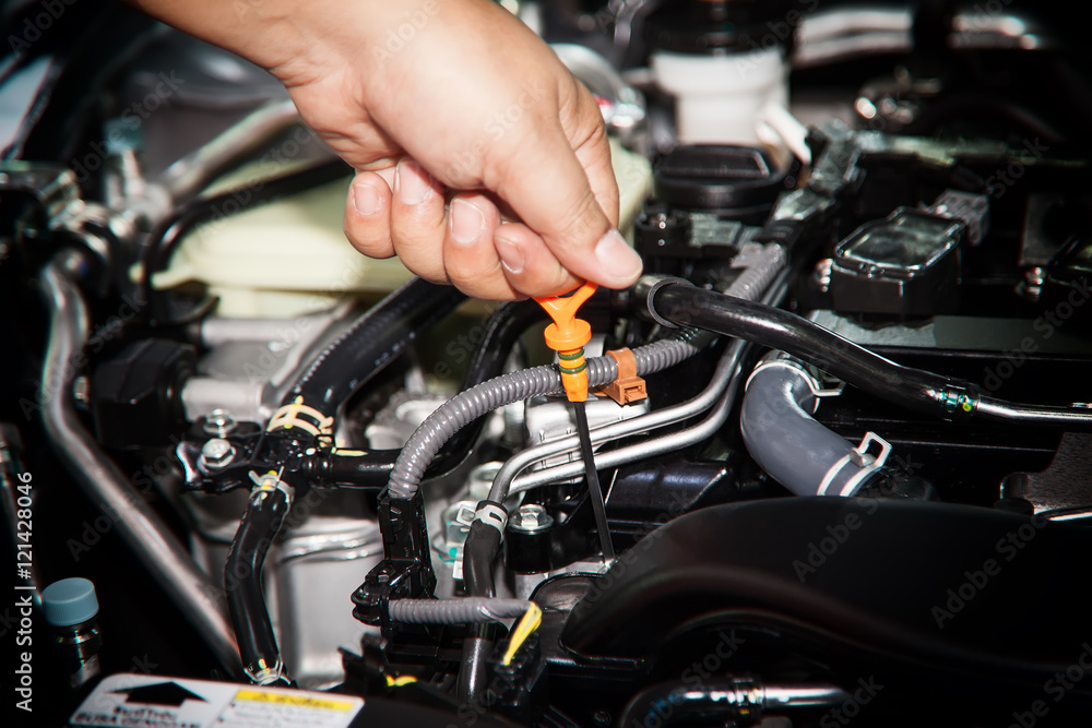 Car repair service, Auto mechanic checking oil level in a engine Car repair service, Auto mechanic checking oil level in a engine