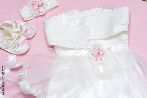 Clothes for baby girl on a pink background. Copy space