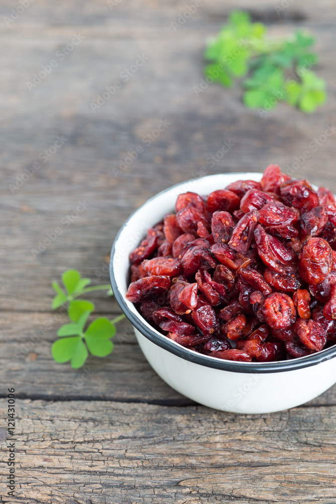 dried cranberries in a bowl on wooden table.
dried cranberries in a bowl on wooden table.