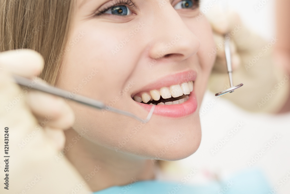 Close-up of female with open mouth during oral checkup at the dentist.Dentist