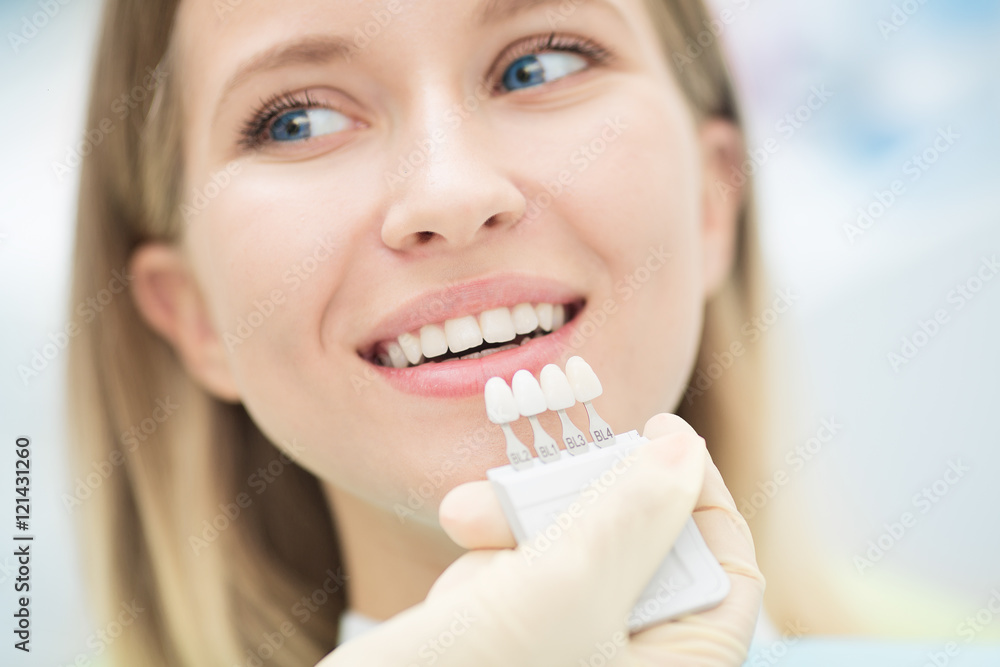 Close up portrait of Young women in dentist chair, Check and select the color of the teeth. Dentist makes the process of treatment in dental clinic office.Dentist Close up portrait of Young women in dentist chair, Check and select the color of the teeth. Dentist makes the process of treatment in dental clinic office.Dentist