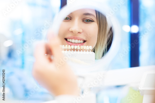 Close up portrait of Young women in dentist chair, Check and select the color of the teeth