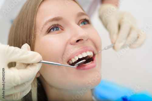 Close-up of female with open mouth during oral checkup at the dentist.Dentist