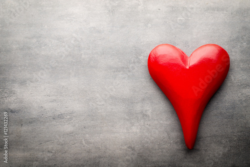 Red heart on the gray metal background.