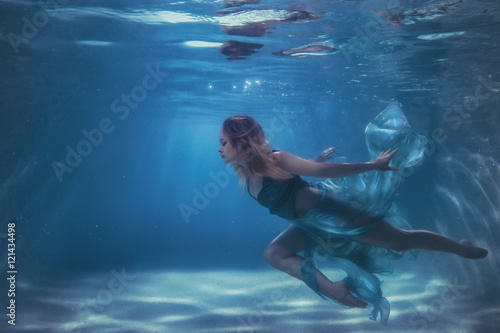 Woman in a dress dives into the water.