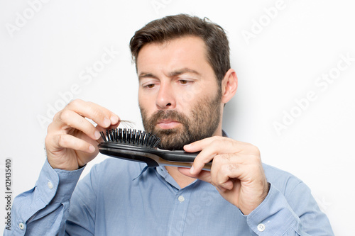 Man looking at hairbrush