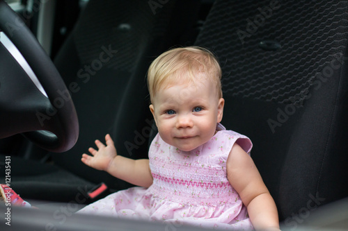 Small cute baby in a car in a warm day