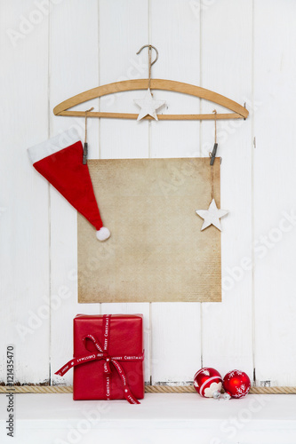 Hintergrund Weihnachten mit Papier Schild und Dekoration in wei    braun und rot mit Geschenk als Weihnachtskarte oder Gutschein weihnachtlich mit Santa Claus.