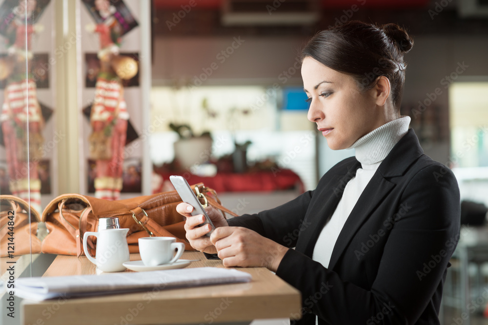 Woman at the bar texting with her mobile phone