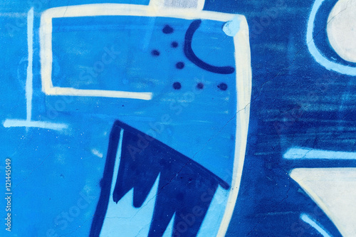 Detail of a graffiti art on a wall. Wall painted in different colors. Abstract blue background. © msnobody