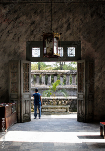 Man talking cellphone in emperior`s tomb, Vietnam. photo