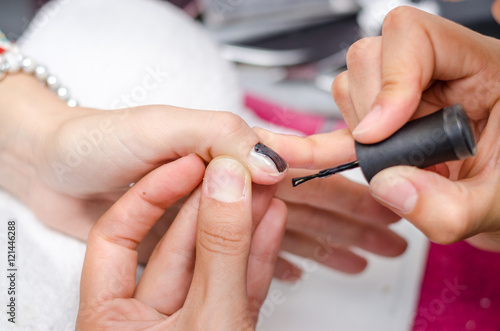 Woman applying black nail polish