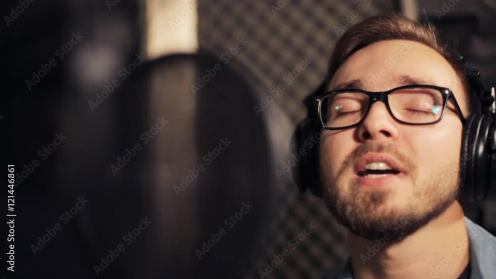 man with headphones singing at recording studio man with headphones singing at recording studio