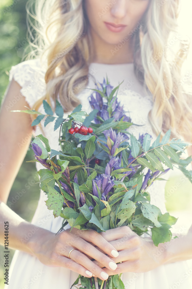 Beautiful bride holds a bouquet of flowers in her hands. Warm sunny summer day. Marriage day, moment before wedding Beautiful bride holds a bouquet of flowers in her hands. Warm sunny summer day. Marriage day, moment before wedding