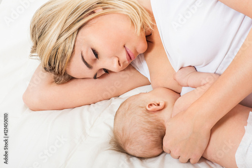Young mother breastfeeds her baby. Breast-feeding.