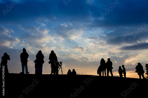 Silhouette of people waiting for sun rise at the mountain peak with dramatic sky, Thailand