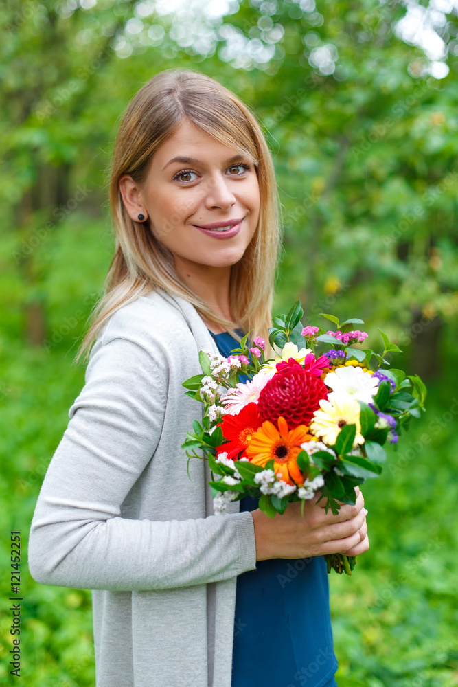 Young smiling woman with a bouquet of flowers Young smiling woman with a bouquet of flowers