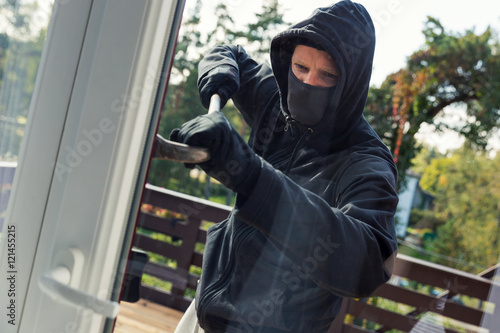 Foto house robbery - burglar opens balcony doors with crowbar