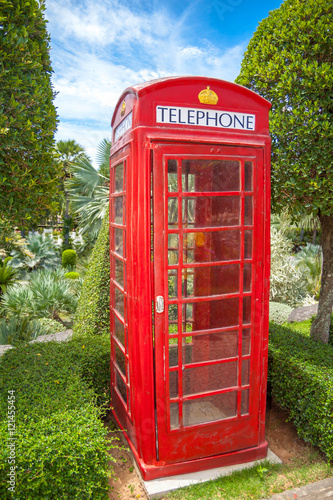 Red London phone booth in a garden