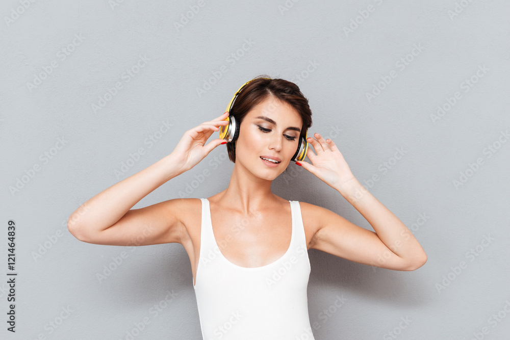 Beautiful brunette young woman listening to music with headphones
