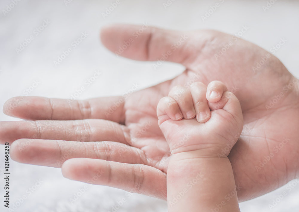 father holding baby hand,soft focus father holding baby hand,soft focus