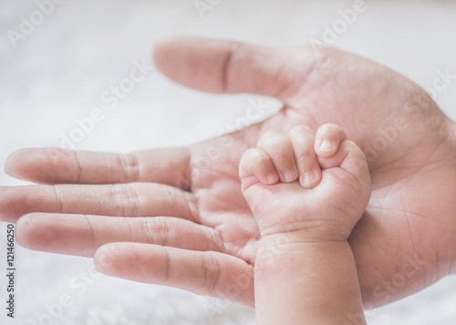 father holding baby hand,soft focus