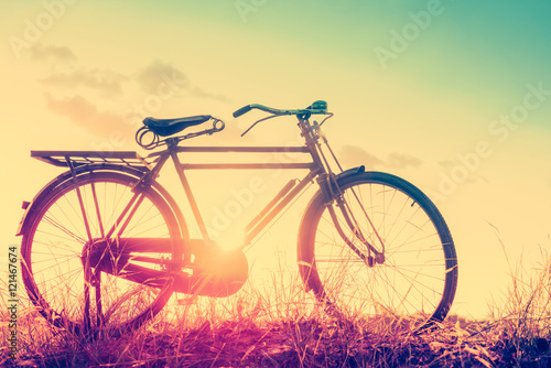 beautiful landscape image with Bicycle at sunset in vintage tone