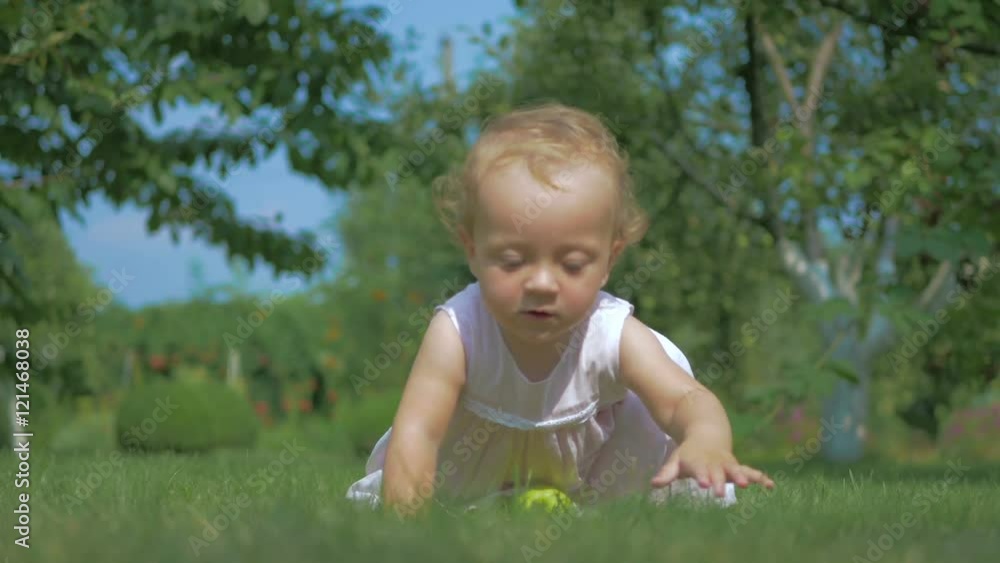 Baby putting green apple on the grass. Baby putting green apple on the grass.