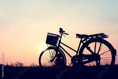 beautiful landscape image with silhouette Bicycle at sunset