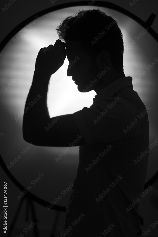 Silhouette of young guy posing in studio