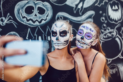 Tableau sur toile Two girls going on Halloween, grimace and make selfie