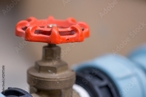 Close-up detail of a red gas valve handle, for emergency shutoffs. They are used in various factories and home plumbing systems. Industry and engineering concept. photo