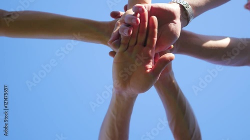 group of young place their hands together in the center of a circle