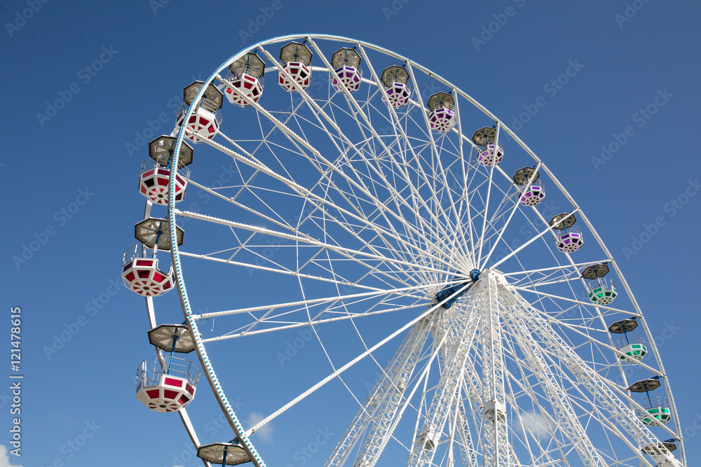 Colorful Ferris wheel against blue summer sky background Colorful Ferris wheel against blue summer sky background