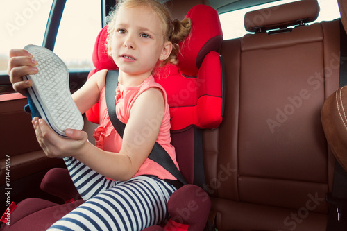 Portrait of happy little child girl sitting comfortable in car s