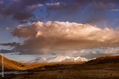 Mountain valley on the dark cloudy sky background. Altay