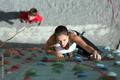 Female Climber and her Child on rock climbing wall