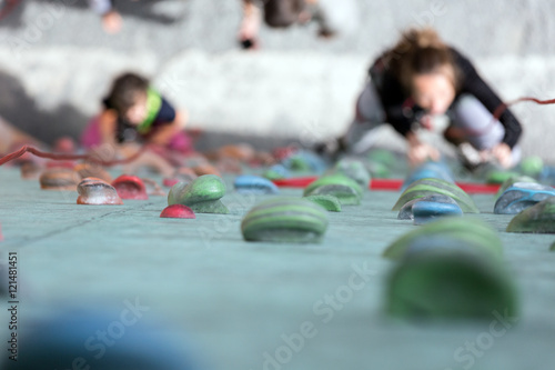 Artificial Climbing wall holds and blurred climbers