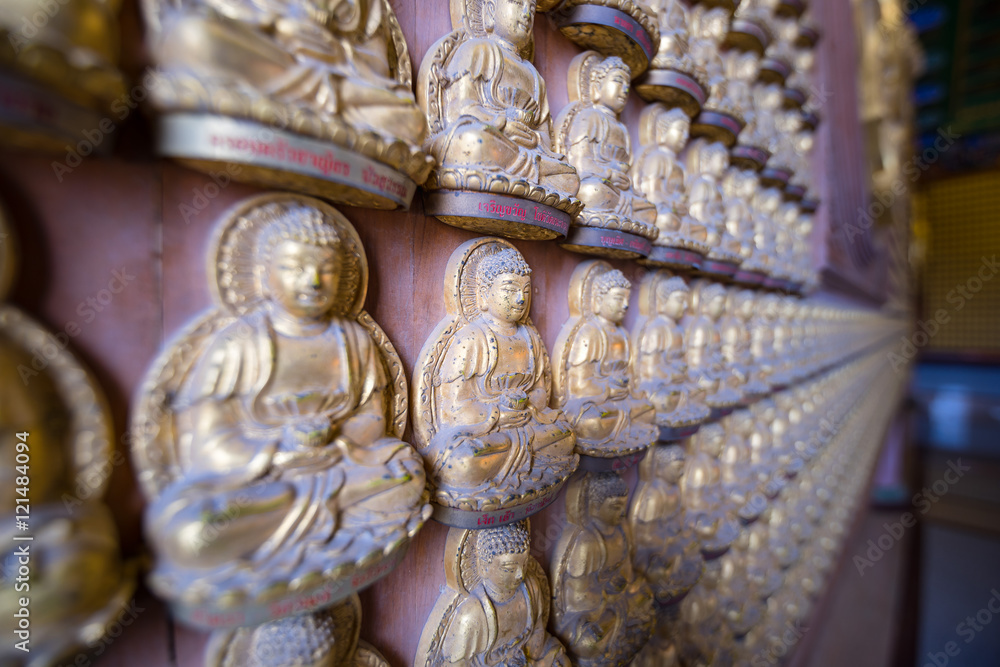 Fototapeta premium Golden buddha statue on the wall in Chinese temple Thailand. (Wa